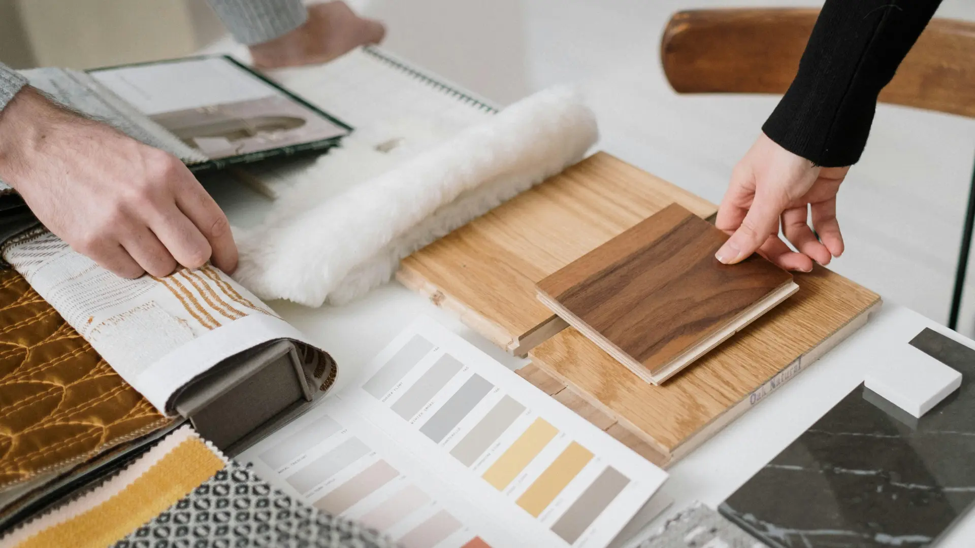 Interior designer meticulously arranging selections, showcasing attention to detail in modern home design